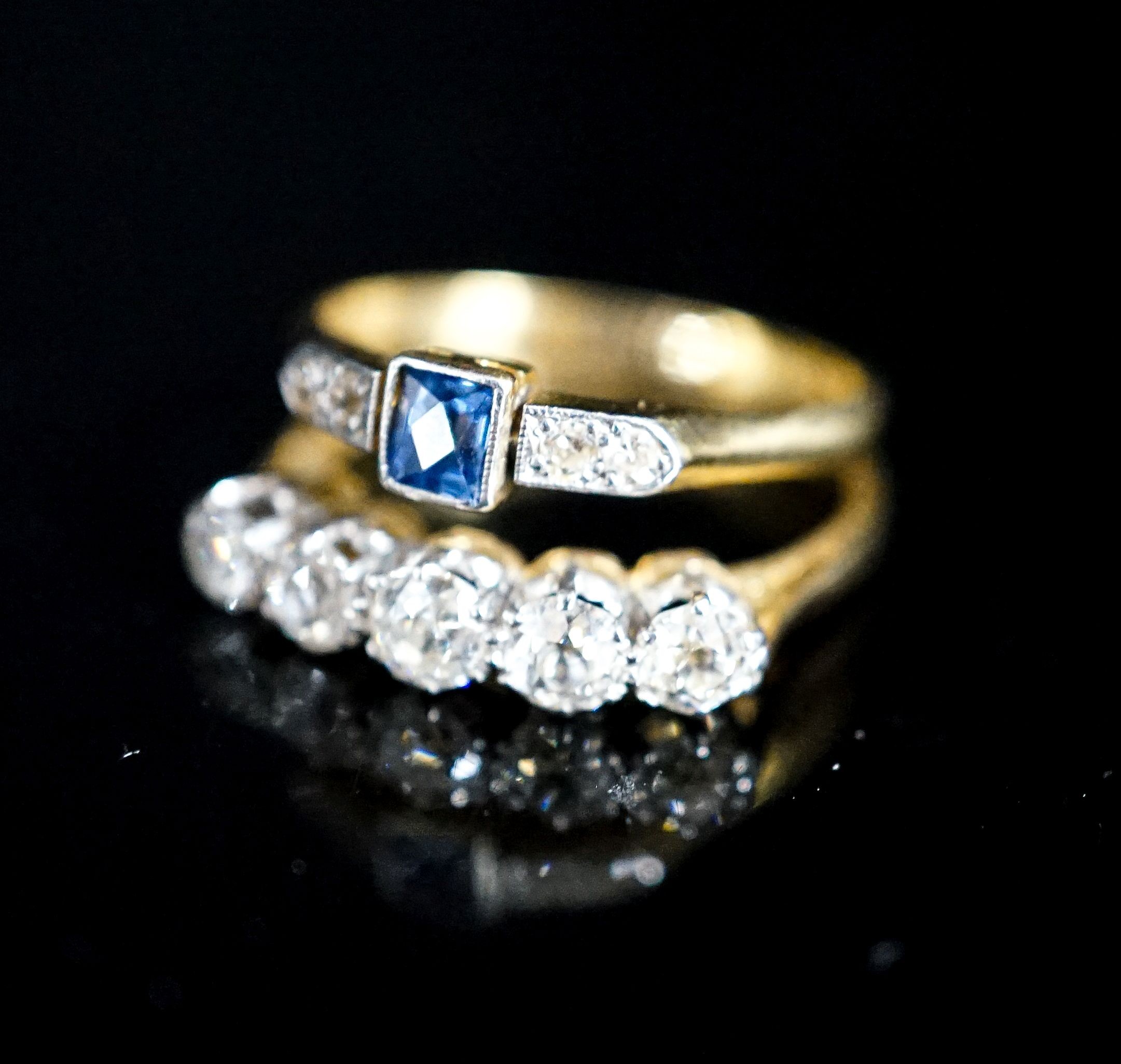 An 18ct and five stone diamond ring and a similar sapphire and diamond ring (now soldered together), gross 4.2 grams.